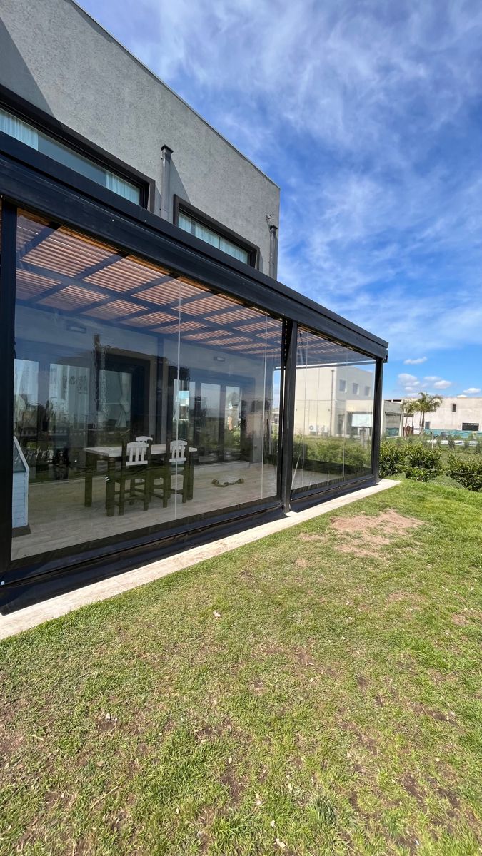 Terraza cerrada con PVC transparente que da al jardín en Colina